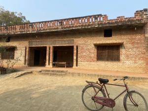 a bike parked in front of a brick building at Anurag singh homestay in Gaura Umarni