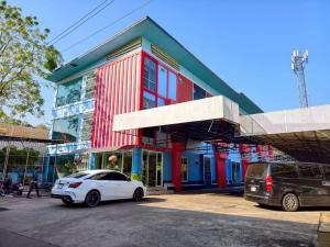 a white car parked in front of a building at Veerakit Grand Hotel Udon Thani in Udon Thani