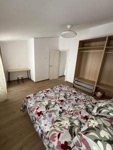 a bedroom with a bed with a floral comforter at Casa Brillantes Completa in Ayerbe