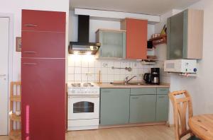 a kitchen with green cabinets and a red refrigerator at Apartment Pawelzig in Kirchdorf +2 photos