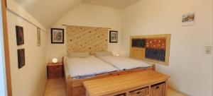 a small bedroom with a bed and a wooden table at Apartment Pawelzig in Kirchdorf