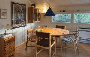 a dining room with a wooden table and chairs at Tziki in Fanø