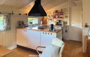 a kitchen with a sink and a stove top oven at Tziki in Fanø +16 photos