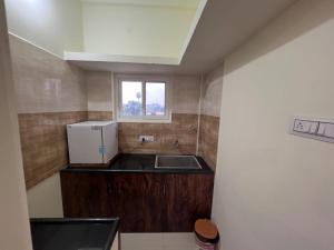 a small kitchen with a sink and a refrigerator at Gold Mountain Wellness Resort in Tiruvannāmalai