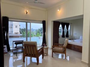 a bedroom with a bed and a table and chairs at Gold Mountain Wellness Resort in Tiruvannāmalai