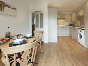 a kitchen and dining room with a table and chairs at Covert Cottage in Gasthorpe