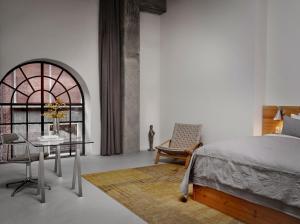 a bedroom with a bed and a table and a chair at Ottilia Heritage in Copenhagen