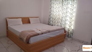 a bedroom with a bed with a wooden frame and curtains at Vishal guest house in Juliāsar