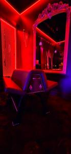 a room with a chair and a mirror with red lights at VILLA CLOSE BRIVE centre - LOVE ROOM - SPA privatif in Brive-la-Gaillarde