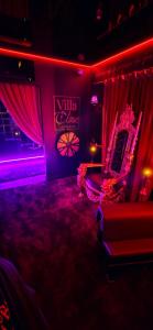a room with a room with a couch and a sign at VILLA CLOSE BRIVE centre - LOVE ROOM - SPA privatif in Brive-la-Gaillarde +6 photos