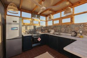 a kitchen with a refrigerator and a stove at Beit Felfel in Esna