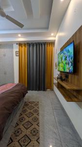 a bedroom with a flat screen tv on a wall at Chill pad in Dehradun