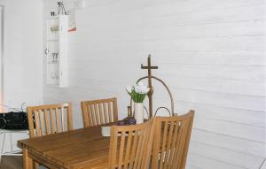 a dining room table with a cross on the wall at Amazing Home In Burseryd With Kitchen in Burseryd