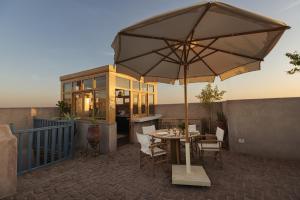 a patio with a table and an umbrella at Beit Felfel in Esna