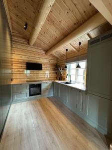 a kitchen with wooden walls and a wooden ceiling at Gunhild-stugu in Skogbygd