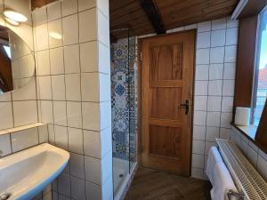 a bathroom with a sink and a wooden door at charmante Pension zentral in Reutlingen +8 photos