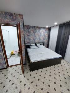 a bedroom with a large bed and a mirror at Uhum Mountain Guesthouse in Yukary-Ukhum