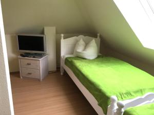a small bedroom with a bed and a television at Nixe in Timmendorf