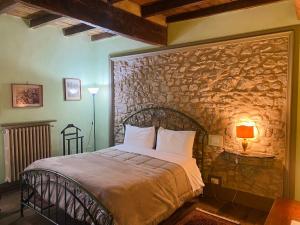 a bedroom with a bed with a stone wall at BORGO VILLA VALENTINI in Scandiano