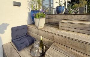 a bottle of wine and a chair on a patio at 2 Bedroom Nice Apartment In Vejle Øst in Bredballe