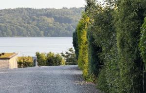 a gravel road next to a wall with a body of water at 2 Bedroom Nice Apartment In Vejle Øst in Bredballe