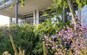 a garden with pink flowers in front of a building at 2 Bedroom Nice Apartment In Vejle Øst in Bredballe +10 photos