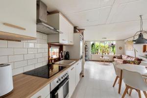 a kitchen and living room with a table and chairs at Chalet De Drentse Rust in Erm