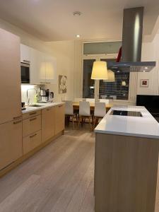 a large kitchen with a counter top and a table at Gella Munkkisaarenkatu 2 in Helsinki