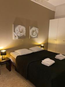 a bedroom with a black bed with two white pillows at Gella Munkkisaarenkatu 2 in Helsinki +4 photos
