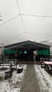 a train station with benches in the snow at Nomaden Kasol in Kasol