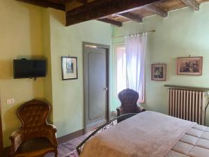 a bedroom with a bed and a tv and a window at BORGO VILLA VALENTINI in Scandiano