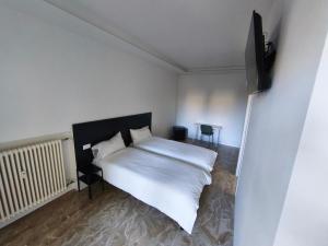 a bedroom with a white bed and a television at Grace House in Padova