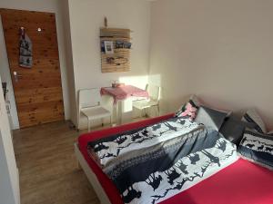 a bedroom with a bed and a table and a door at Kleines aber feines Studio in Zuoz