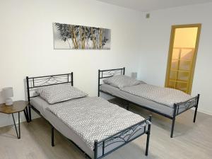 two beds in a room with a table and a mirror at Monteurwohnung in Coswig in Coswig