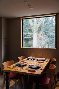 a dining room table with chairs and a large window at 奈良春日 鹿のや in Nara
