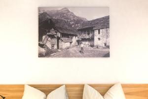 a black and white photo of a man standing in front of houses at MyVerzasca Boutique Hotel in Brione +36 photos