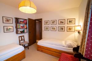 a bedroom with two beds and a lamp and a chair at Chesa Cuntainta B 4pax - St Moritz in St. Moritz