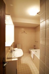 a bathroom with a sink and a bath tub at Chesa Cuntainta B 4pax - St Moritz in St. Moritz +20 photos