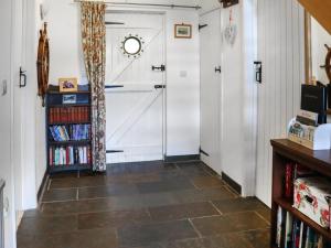a hallway with a white door and a book shelf at Holly Cottage in Angle