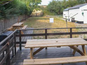 a wooden bench sitting on top of a wooden deck at Holly Cottage in Angle