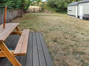 a wooden picnic table sitting on a deck in a yard at Holly Cottage in Angle