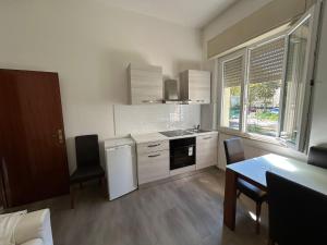 a kitchen with white appliances and a table and chairs at Hotel Bianca Vela in Rimini