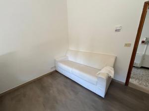 a white couch sitting in a corner of a room at Hotel Bianca Vela in Rimini