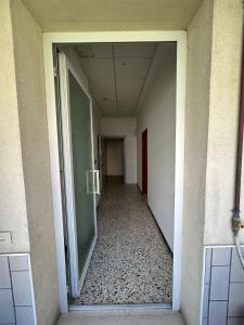 an empty hallway of an office building with a glass door at Hotel Bianca Vela in Rimini