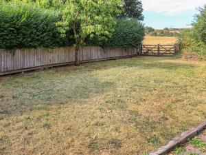 a yard with a fence and a tree at Holly Cottage in Angle +13 photos