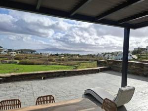 a patio with chairs and a table and a view at sea melody tinos 2 in Agios Sostis