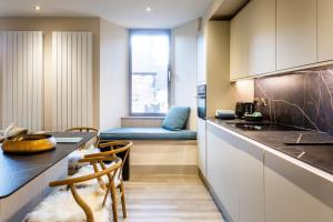 a kitchen with a counter and a table and chairs at Arran Shores Luxury Shorefront Apartment 2 in Lamlash +11 photos