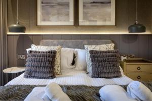 a bedroom with a bed with pillows and towels on it at Arran Shores Luxury Shorefront Apartment 2 in Lamlash