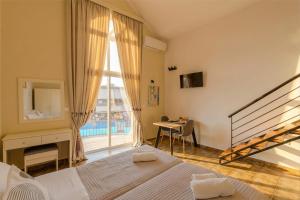 a bedroom with a bed and a window and a desk at Ilios Mare Hotel in Agia Marina Nea Kydonias +78 photos