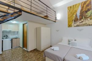 a bedroom with a large bed and a kitchen at Ilios Mare Hotel in Agia Marina Nea Kydonias